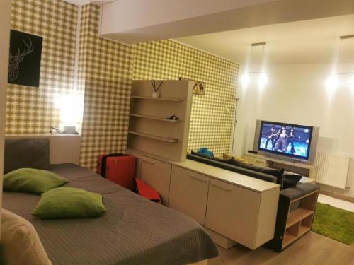 a bedroom with a bed with a desk and a television at Apartament Aosta Central Sinaia in Sinaia