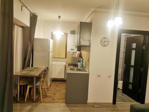 una pequeña cocina con mesa y nevera en Apartament Aosta Central Sinaia en Sinaia