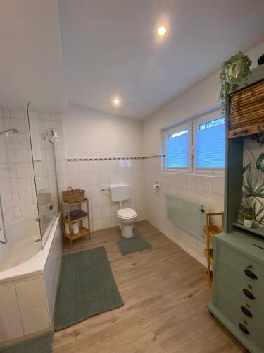 a bathroom with a tub and a toilet and a shower at Ferienhaus Göbel´s gute Stube in Wirfus