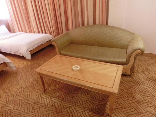 a living room with a couch and a coffee table at New Asia Hotel in Guangzhou
