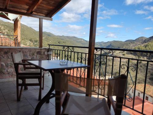 a table and chairs on a balcony with a view at Kristi's Homes - "Beautiful Attic" in Dimitsana in Dhimitsana