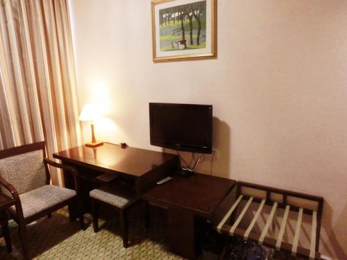 a hotel room with a desk with a television on it at New Asia Hotel in Guangzhou