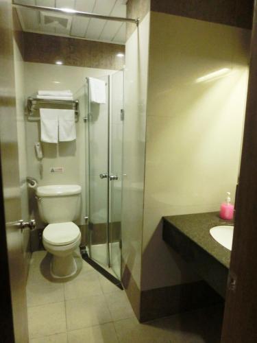 a bathroom with a shower and a toilet and a sink at New Asia Hotel in Guangzhou