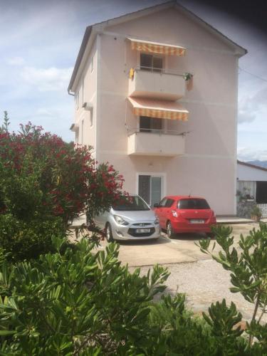 two cars parked in front of a building at Botic Apartments in Šilo