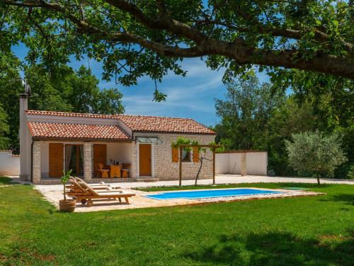 a house with a picnic table and a pool at Villa Bilen in Medulin