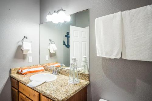 a bathroom with a sink and a mirror at 7 Bedroom Home STEPS TO THE BEACH With 4 Patios and Pool! Sleeps 20 in Port Aransas