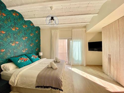a bedroom with a large bed with a blue wall at Abbott apartment - 1 min from the beach - 100m2 - sleeps 8 in Sitges