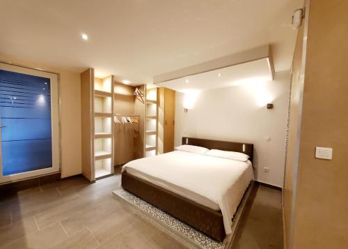 a bedroom with a bed and a large window at Appartement en bord de lac avec jaccuzi in Publier
