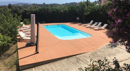 - une piscine sur une terrasse en bois avec des chaises longues dans l'établissement U Paradisu - Villa 10/12 pers avec piscine privée, à Alata