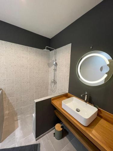 a bathroom with a sink and a mirror at Villa Pwintosel 1, calme et confort à 300m de l'océan in Saint-Leu