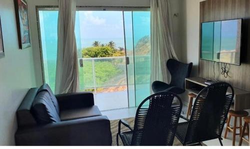 a living room with a couch and chairs and a large window at Casa Lofstrom uma luxuosa com linda vista! in Tibau