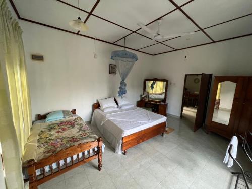 a bedroom with a bed and a mirror at Summer Ridge - Homestay in Ratnapura