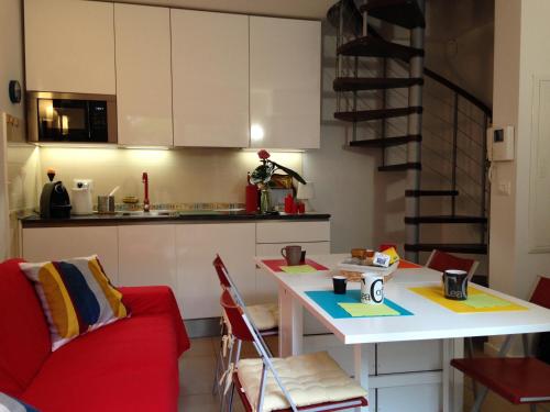une cuisine avec un canapé rouge et une table dans une pièce dans l'établissement Monaco terrace, à Beausoleil