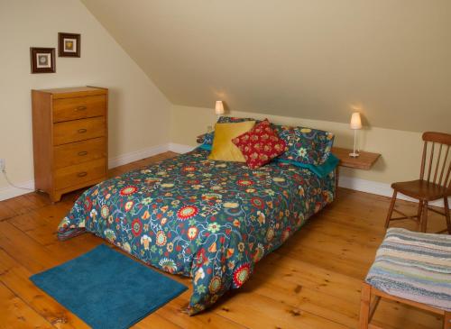 sypialnia z łóżkiem i drewnianą podłogą w obiekcie Gîte Au Blanc Marronnier w mieście Racine