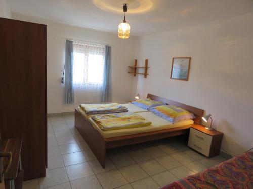 a bedroom with two beds and a cross on the wall at Apartman Vir Gogo br 5 in Vir