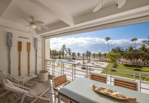 balcón con mesa y vistas a la piscina en Juan Dolio Costa del Sol en Juan Dolio