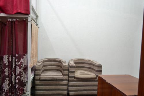 two chairs sitting in a room with a wall at HOSTEL NABI BOBO in Samarkand