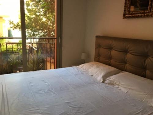 un lit dans une chambre avec une grande fenêtre dans l'établissement Monaco terrace, à Beausoleil