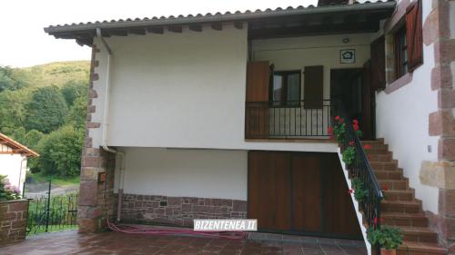 a house with a door and a balcony at Bizentenea in Zugarramurdi