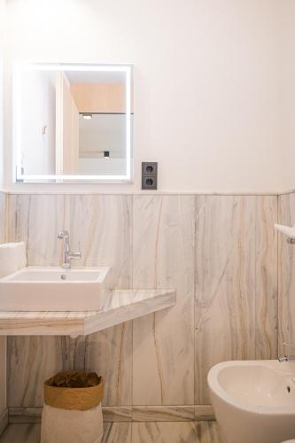 a white bathroom with a sink and a mirror at Koasa-Hof Ganzes Ferienhaus und Sauna 5 Zimmer 240mq in Cadipietra