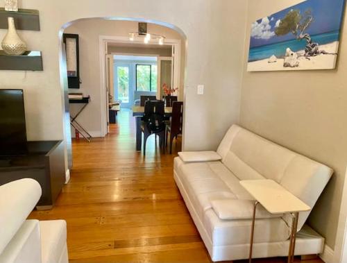 a living room with a white couch and a table at Entire private Beautiful 2 Bedroom plus Den House with gated front&back yard and Free parking 10min drive to the beach in Miami