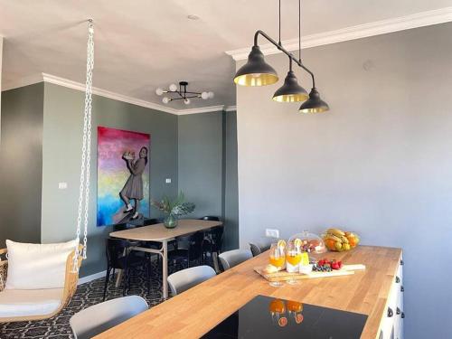 a dining room with a wooden table and a painting at APTER-Boutique Apartment אפטר - דירת בוטיק בכנרת in Tiberias