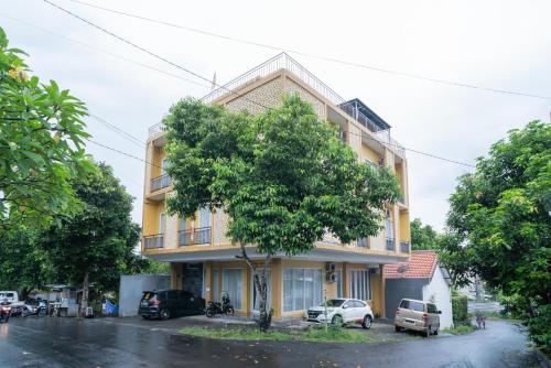 a building with a tree in front of it at RedDoorz near ITDC Nusa Dua in Nusa Dua
