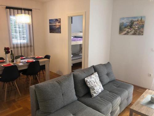 a living room with a couch and a dining room at Apartman Ivešić in Makarska