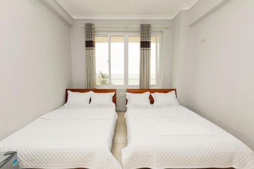 Säng eller sängar i ett rum på Khách sạn Hà Nội 2 Mặt Biển Sầm Sơn