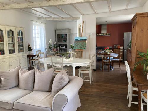un salon avec un canapé blanc et une table dans l'établissement Le Clos de Longas - Gite et Chambre d'hôtes, à Sainte-Foy-de-Longas