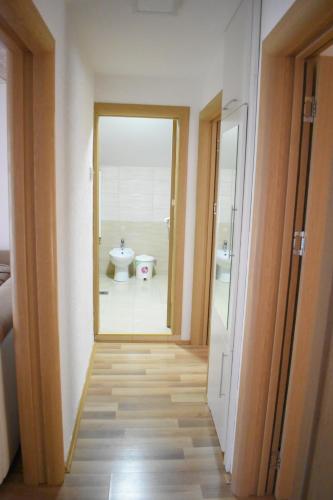 a hallway leading to a bathroom with a toilet at Apartments Holiday in Vranje