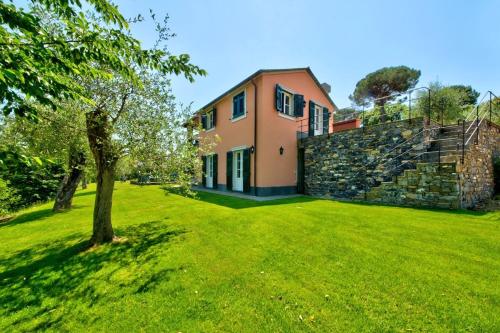 ein Haus mit einem grünen Garten mit einem Baum in der Unterkunft I Giardini di Camogli - VILLA RUMANIN, garden&pool in Camogli