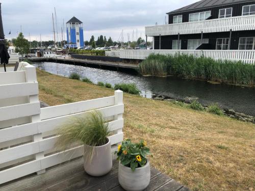 a white fence with two plants in pots on a dock at Perle Øer Maritime ferieby Ebeltoft in Ebeltoft