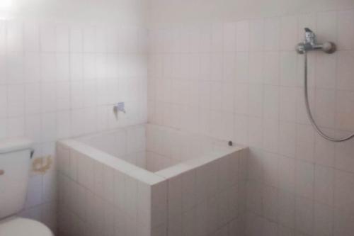 ein Badezimmer mit einer Dusche, einer Badewanne und einem WC in der Unterkunft Mataram Cottage Syariah Mitra RedDoorz in Pasakon 1