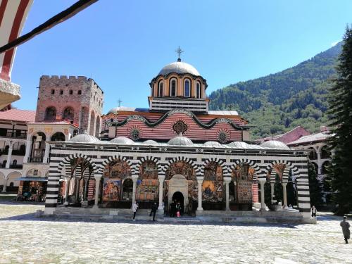 a large building with a tower on top of it at Семеен Хотел "При Мечо" in Rilski Manastir