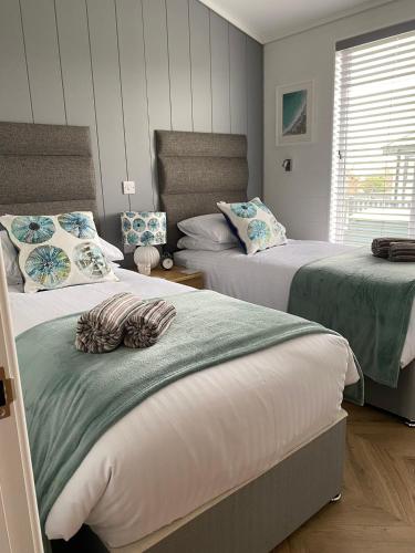 a bedroom with two beds with green and white at Padstow Lodge - Padstow Holiday Village in Padstow
