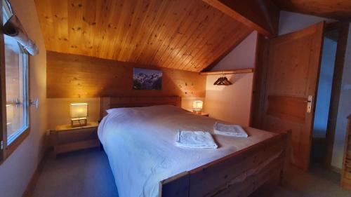 a bedroom with a large bed in a wooden room at Les Cristallieres Venosc in Vénosc