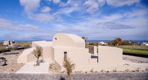 Cette maison blanche offre une vue sur l'océan. dans l'établissement Santopaz Suites, à Oia