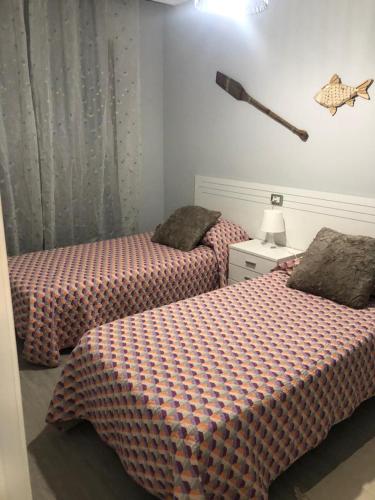 a bedroom with two beds and a bat on the wall at Residencial Atlantico I in Costa Del Silencio