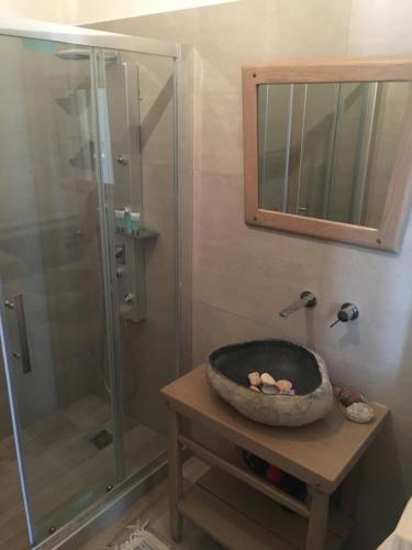 a bathroom with a shower and a bowl on a table at Καμάρα Χωριό Φοινίκι , Kamara Finiki Village in Moláoi