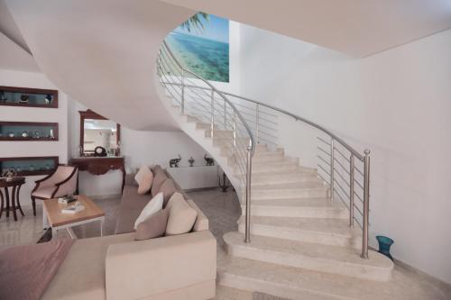 a spiral staircase in a living room with a couch at Magnifique Villa Avec Piscine, Pour Vos Vacances ! in Monastir
