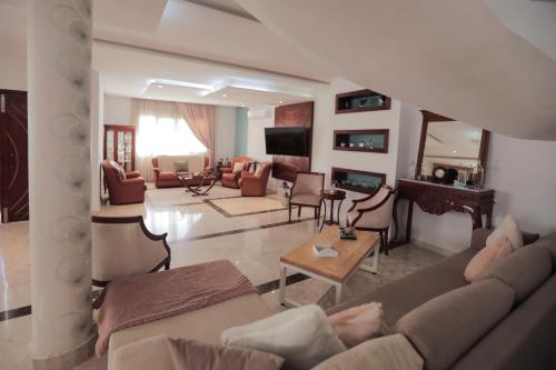 a living room with a couch and a table at Magnifique Villa Avec Piscine, Pour Vos Vacances ! in Monastir
