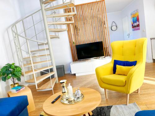 sala de estar con silla amarilla y TV en Apartamenty Lux Pogorzelica, dwupoziomowy, dwie łazienki, dwa tarasy, pies gratis!, en Pogorzelica