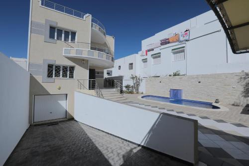 an external view of a building with a swimming pool at Magnifique Villa Avec Piscine, Pour Vos Vacances ! in Monastir