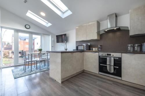 eine Küche mit Küchengeräten aus Edelstahl und einem großen Fenster in der Unterkunft Townhouse for Professionals (5 Bedroom 5 Ensuite) in Ipswich