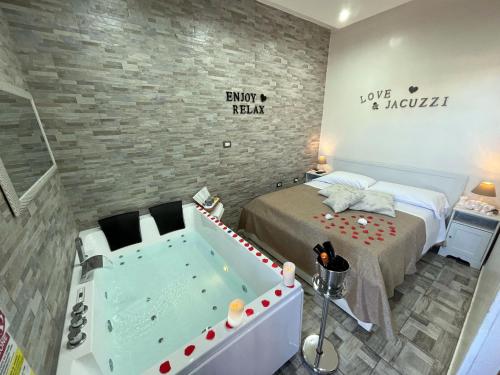 a bedroom with a bed and a tub in a room at Il FAUNO - Suite & SPA in Scafati