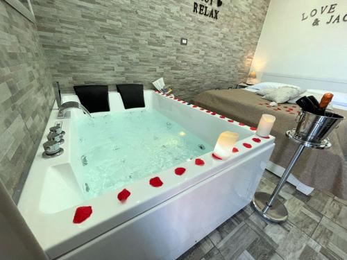 een badkamer met een bad en een bed bij Il FAUNO - Suite & SPA in Scafati