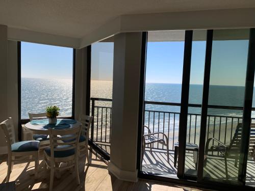 a balcony with a table and chairs and the ocean at Absolute Beach Pet Friendly in Myrtle Beach