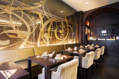 une rangée de tables dans un restaurant orné d'une fresque murale dans l'établissement Chambellan Morgane, à Paris