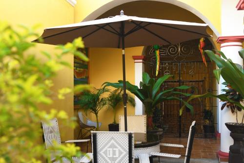 a table and chairs with an umbrella on a patio at Hotel Casa Danna in Colima